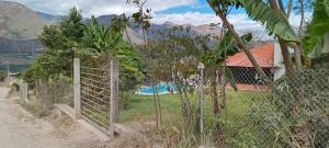 a fence in front of a house with a pool at Quinta AM Vacaciones y Turismo in Santa Isabel