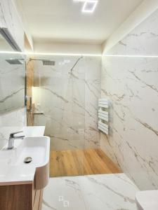 a white bathroom with a sink and a shower at Romantic Lake View Apartment with Balcony and Parking in Orselina Locarno in Orselina +6 photos
