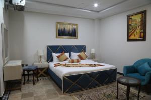 a bedroom with a king sized bed and two chairs at Nizalia Hotel by Marvelous Holidays in Patriata +18 photos