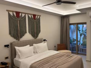 Schlafzimmer mit einem Bett und einem Fenster mit einem Balkon in der Unterkunft Τhe Noverian Antama Organic Beach Resort Chania in Agia Marina + 132 Fotos