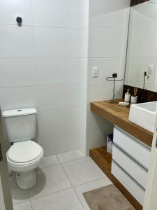 un bagno bianco con un water e un lavandino di Apto alto padrão na Praia de Torres - 550m do mar a Torres Altre 23 foto