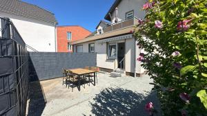 a patio with a wooden table and a fence at zentrale 3 Zimmer 73 m2 Ferienwohnung mit Terrasse in Lübeck
