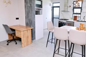 - une cuisine avec une table en bois et des chaises blanches dans l'établissement Smart & Modern 2BR Home in Secure Gated Area, à Phoenix