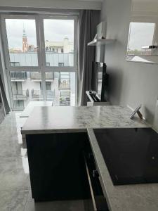 cocina con encimera y ventana grande en Apartament Poznańska 24, en Bydgoszcz 3 fotos más