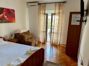 a bedroom with a bed and a living room at Apartmani Vedrana Sutomore in Sutomore