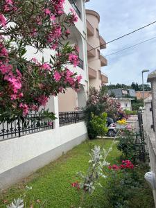 a house with pink flowers on the side of it at Apartmani Vedrana Sutomore in Sutomore