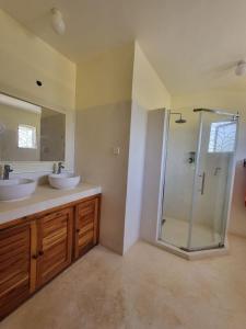 a bathroom with two sinks and a glass shower at Malindi 5bedroom Villa in Malindi