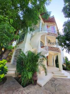a large white house with stairs and trees at Malindi 5bedroom Villa in Malindi +22 photos