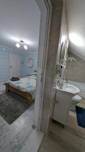 un bagno con un letto, un lavandino e uno specchio di Cazare La Piatra Buhei a Câmpulung Moldovenesc