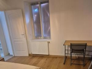 a room with a table and a chair and a window at Le lumineux-T2 calme-animaux acceptés-place auto in Saint-Gaudens