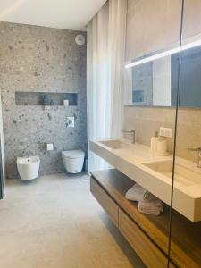 a bathroom with two sinks and a tub and a toilet at Casa Mare e Macchia in Propriano