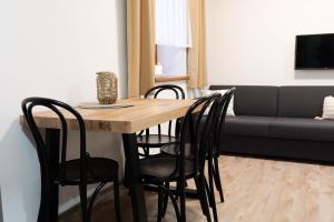 a dining room table with chairs and a couch at Horský klid Klínovec in Loučná pod Klínovcem +8 photos