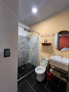 a bathroom with a toilet and a sink and a shower at AraMacao in La Macarena