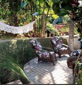 three wicker chairs sitting on a brick patio at Sítio dona chica in Domingos Martins