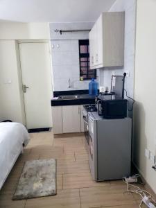 a small kitchen with a sink and a stove at Krystal suites in Juja +9 photos