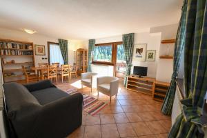 a living room with a couch and chairs and a television at Cabin in front of Grand Paradis and Arolla in Cogne