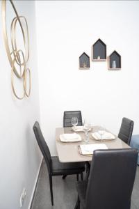 a dining room with a table with chairs and a chandelier at New Apparts 3 Douala in Douala