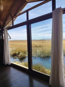 a room with a window looking out at a field at Sky Domo Titicaca Lodge in Puno +5 photos