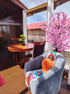 a living room with a blue chair and a table at Sky Domo Titicaca Lodge in Puno