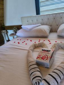 a bed with a book and red hearts on it at Atrijland Cazin in Cazin +29 photos
