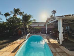 a swimming pool in a backyard with a pergola at Pousada da Renata in Jericoacoara