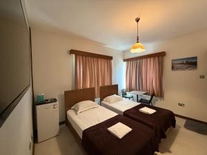 a hotel room with two beds and a desk at Happiness City in Iskele