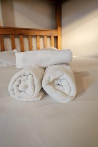 a pile of towels sitting on top of a bed at Casa e Kitnets Imbituba Praia da Vila in Imbituba