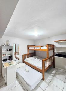 a room with two bunk beds and a kitchen at Casa e Kitnets Imbituba Praia da Vila in Imbituba