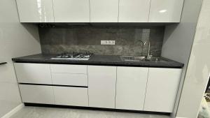 a white kitchen with a sink and a stove at Lux house in Bălţi