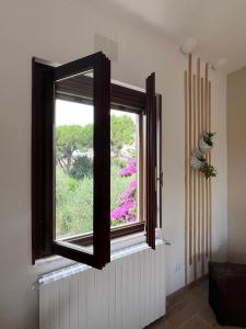 d'une fenêtre avec vue sur le jardin. dans l'établissement Villa Biancaluna, à San Felice del Benaco