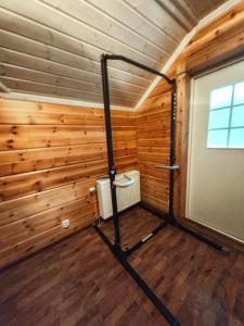 Una habitación con paredes revestidas de madera y un gimnasio. en Homely Loft, en Punkaharju