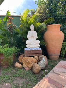a statue sitting next to two large vases at Vila alecrim Guest House in Búzios