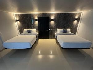 a bedroom with two beds with white sheets at Casa Catalana in San Vito