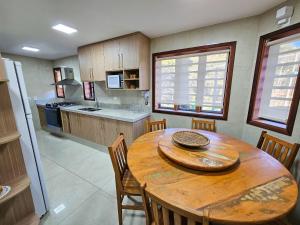 a kitchen with a wooden table and chairs in a kitchen at Refúgio das Nuvens | by The Lodges in Campos do Jordão