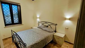 a bedroom with a bed and a window at L'Antico Borgo di Leonardo in Monte San Biagio