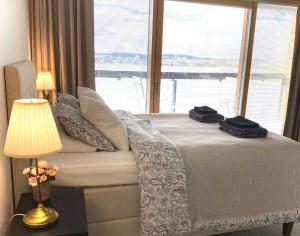 a bedroom with a bed with a large window at Sky Studio in Jyväskylä