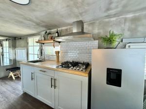 a kitchen with white cabinets and a white refrigerator at Custom Tiny House in Valle in Francisco Zarco