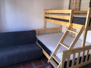a room with two bunk beds and a couch at Habitación en Apartamento cerca a Parque de Bello Antioquia in Bello