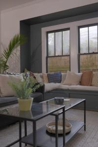 a living room with a couch and a table at Clinton Street House: Your Lafayette Home Base in Lafayette