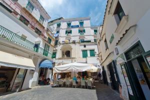 a group of people sitting under an umbrella on a street at Casa Ermelinda in Amalfi