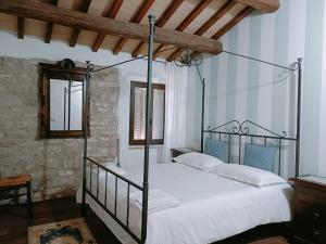 a bedroom with a metal canopy bed with white sheets at villa colticciola Agriturismo Marche in Cagli +160 photos