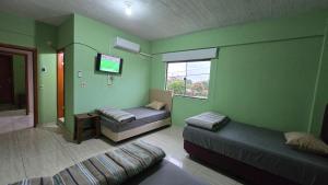 a room with two beds and a tv and a couch at Rd hotel in Colonia Felicidad