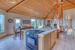 eine Küche und ein Esszimmer mit einem Herd und einem Tisch in der Unterkunft Cape View Escape in Pacific City