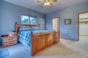 Schlafzimmer mit einem Holzbett und einem Deckenventilator in der Unterkunft Cape View Escape in Pacific City