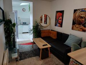 a living room with a black couch and a table at La clef des cœurs in Montargis