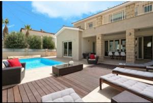 a backyard with a swimming pool and a house at Villa Kristia in Paphos City