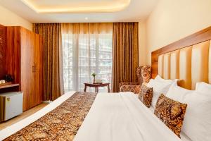 a hotel room with a bed and a window at Hotel Classic Hills Bhagsunag Luxury Stay #Best Hotel in Mcleodganj #Mountain View Balcony Rooms #Spacious Parking #Prime Location in Dharamshala #Near Bhagsunag Waterfall #Top Selling Property in Mcleodganj in Dharmsala