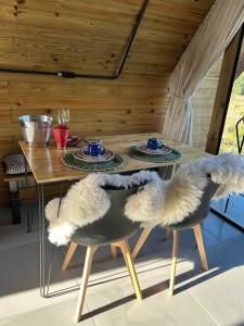 a wooden table with two chairs and a table with two plates at Chalé aconchegante em madeira in Schroeder +23 photos