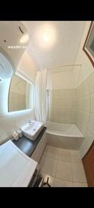 a bathroom with a tub and a sink and a bath tub at Apartman NN Trebinje in Trebinje +61 photos