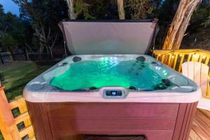 a jacuzzi tub sitting in a yard at Neon Vibes Outdoor TV Hot Tub Arcade Room in Canyon Lake